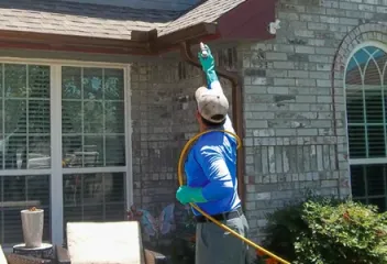 technician spraying exterior of home for pest protection